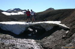 Some people playing with a snow bridge