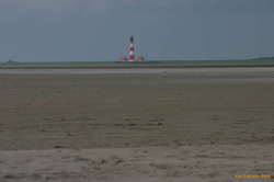 A long beach, a wide swath of green, and a lighthouse