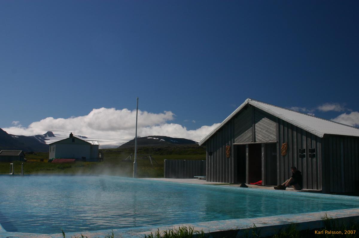 A glacier and a hot pool, under a blue sky