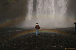 Alex stands in a double rainbow